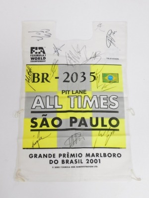 A Formula 1 World Championship Sao Paulo pit lane tabbard for 2001, bearing indistinct signatures, possibly to include Michael Schumacher, Rubens Barrichello, Mika Hakkinen, Nick Heidfeld, Kimi Raikkonen, and others.