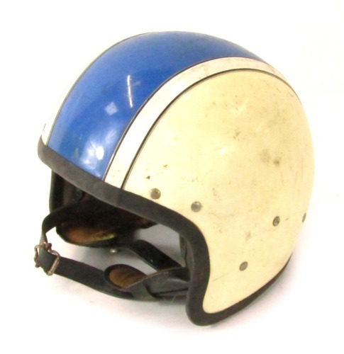 A motorcycle racing helmet, in cream with blue stripe.