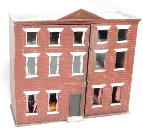 A three storey Tudor style doll's house, with brick and windowed frontage, with a fitted interior, some furniture, 86cm high, 93cm wide, 37cm deep.