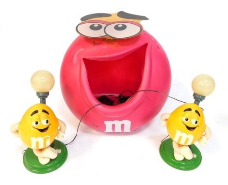 A pink M&M storage cupboard, and two yellow M & M bedside lamps. (3)