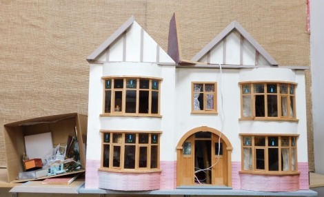 A Tudor revival style dolls house, with brick frontage and bay windows, with stained glass entitled Fairbanks, over two storeys, 64cm high, 110cm wide, 65cm deep, with a small group of accessories. (a quantity)