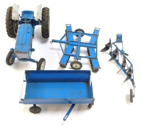 An Ertl Ford 4000 tractor set, with trailer and two ploughs, in blue.