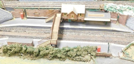 A Scenic Railway layout, with mounted buildings, track and crossings, 182cm high, 120cm wide, 32cm deep.