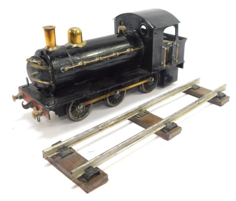 A tin plate locomotive, black livery, with track.