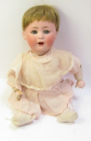 A Jutta 20thC bisque headed doll, with short blonde hair, roll blue eyes and articulated limbs, marked Jutta 1914, in pink dress, with squeaker, 45cm high. (AF)