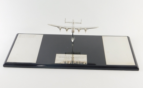 An Elizabeth II silver Bomber Command memorial plaque, formed as a Lancaster Bomber, on a plinth base dedicated to the men and women of Bomber Command 1939 - 1945, the aeroplane London, 2007, 53cm wide.