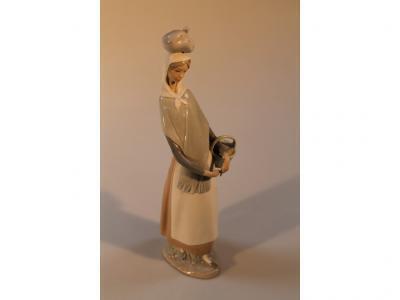 A Lladro figure of a lady with a basket