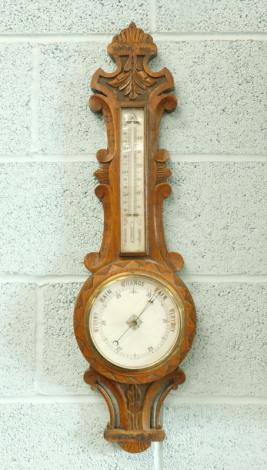 A late Victorian carved oak aneroid barometer