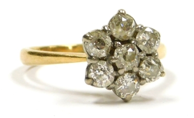 A diamond flower head ring, set with seven rose cut diamonds, set in white and yellow metal, stamped 18ct, approximately 0.85ct, size O, 3.6g.