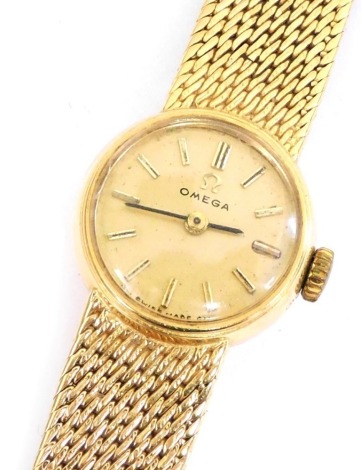 An Omega lady's 18ct gold cased wristwatch, the circular dial bearing gold batons, on an integral mesh strap, with snap clasp, 30.8g all in.