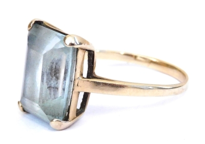 An aquamarine dress ring, the emerald cut stone high claw set in yellow metal, approx 5ct, size Q/R, 3.3g.