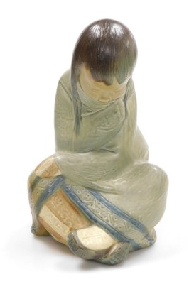 A Lladro matte porcelain figure of an Eskimo girl, in seated position, printed and impressed marks, 30cm high.