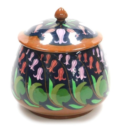 A Wileman and Co Foley Intarsio jar and cover, decorated with bluebells against a dark blue ground, with brown highlights, pattern number 3055, printed marks, 13cm high.