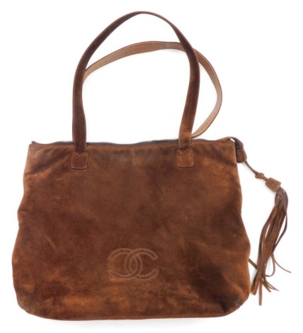 A Chanel brown suede tote bag, with zipped top with a suede fringe tassel, the interior with two zipped pockets, no authentication certificate, 29cm high, 35cm wide.