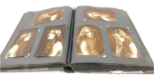 An early 20thC postcard album, containing colour portraits of Miss Gladys Cooper, sentimental, in memorium, religious, topographical, greetings, silk World War I postcards, etc.