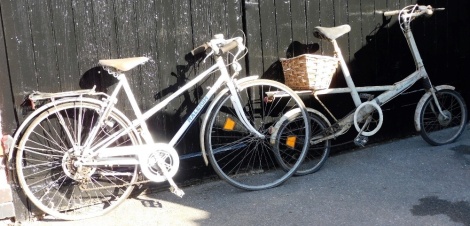 A Raleigh Lady Sprite bicycle, in white trim with a Brooks B72 seat, and a Moult Bicycles bicycle, in white trim with a rear wicker basket. (2)