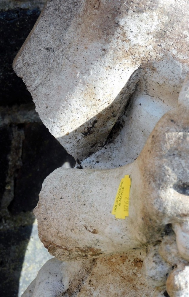 A composition garden statue, of a scantily clad lady, in classical