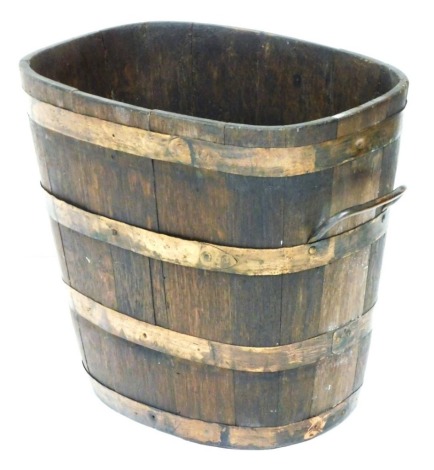 A coopered twin handled oak bucket or planter, of tapering form, with copper banding, 43cm high, 47cm wide.