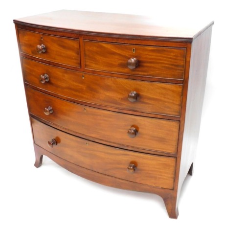 A Victorian mahogany bowfronted chest of drawers, the top with a reeded edge above two short and three long drawers, each with turned wooden handles on splayed feet, 103cm high, 52cm deep, 104cm wide.