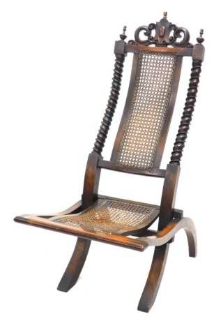 A Victorian walnut and caned folding side chair, with spirally turned supports and shaped crest.