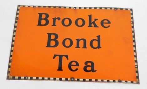 A Brooke Bond Tea enamel advertising sign, on orange ground with chequered border, 51cm x 76cm.