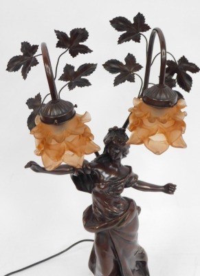 An Art Nouveau bronze effect table lamp, of a semi clad female, with fluted orange shades and vine supports, 79cm high. - 2