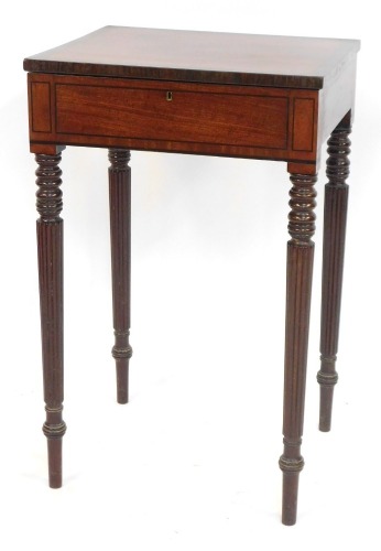 An early 19thC mahogany work table, with rectangular figured top and rosewood cross banded decoration on reeded and tapered legs, with a green fitted interior, 76cm high, 49cm wide, 42cm deep.