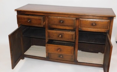 An oak dresser, with arrangement of two cupboard doors and two drawers, and central four drawer section, one handle lacking, 91cm high, 152cm wide, 52cm deep. - 2