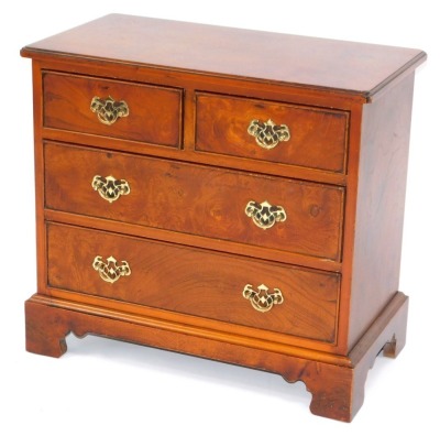 A walnut chest of drawers, two short and two long drawers, with brass handles on bracket feet, 60cm high, 66cm wide, 35cm deep.