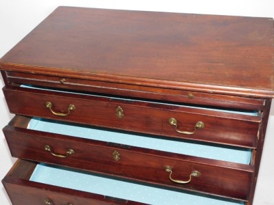 A George III mahogany chest of drawers, with arrangement of a slide and four long drawers, with brass swing handles and escuteons, on bracket feet, 82cm high, 81cm wide, 44cm deep. - 2