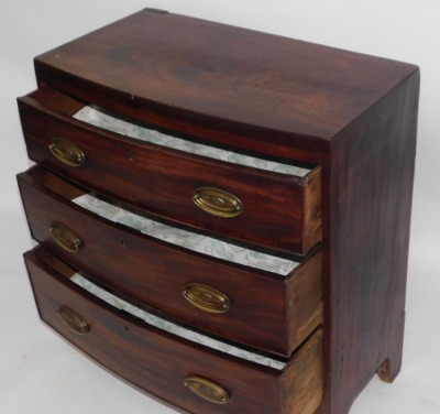 A 19thC bowfront chest, with three drawers, with brass oval and back plates and swing handles, bracket feet, 82.5cm high, 75cm wide, 37cm deep. - 2