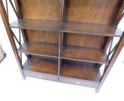 A hardwood bookcase, formed as two parts with a single and double section, with shaped sides and two drawer base, 176.5cm high, 88.5cm wide, 34cm deep, the double section 130cm wide, retailed by Laura Ashley. (2) - 2