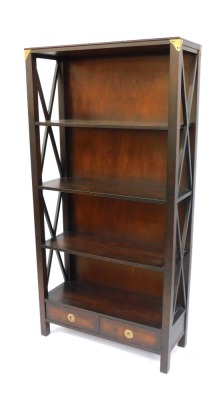 A hardwood bookcase, formed as two parts with a single and double section, with shaped sides and two drawer base, 176.5cm high, 88.5cm wide, 34cm deep, the double section 130cm wide, retailed by Laura Ashley. (2) - 3