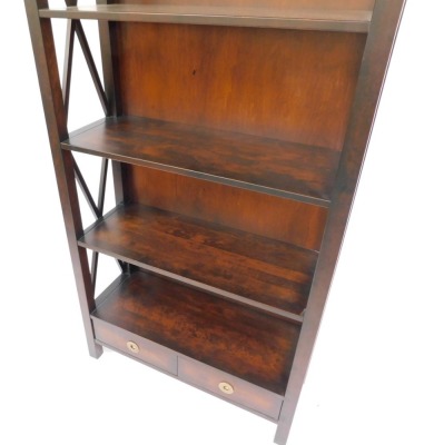 A hardwood bookcase, formed as two parts with a single and double section, with shaped sides and two drawer base, 176.5cm high, 88.5cm wide, 34cm deep, the double section 130cm wide, retailed by Laura Ashley. (2) - 4