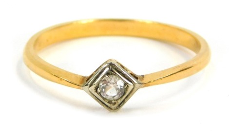 A diamond dress ring, the central diamond shaped rub over setting, with round brilliant cut diamond, in platinum, on a yellow metal plain band, unmarked, size R½, 2.5g all in.