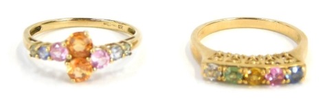 Two dress rings, each of multi stone design, one with twist centre, yellow metal stamped 9kt, ring size O, and another set with five stones on a raised shank, yellow metal, marked 9k, ring size N, 4.4g all in. (2)