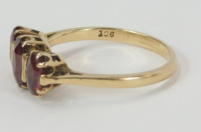 A garnet dress ring, set with three oval garnets in claw basket setting, on a yellow metal band, stamped 9ct, ring size L, 2.2g all in. - 2