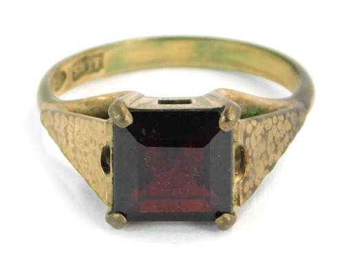 A dress ring, set with square cut garnet on bark effect shoulders in claw setting, ring size M½, yellow metal, stamped 9ct, 3.3g all in.