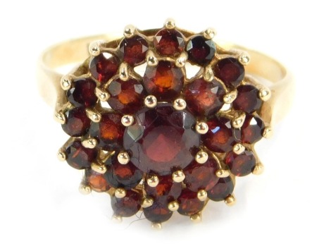 A 9ct gold garnet cluster ring, with three layers of garnets each in a raised basket claw setting, ring size M, 2.9g all in.