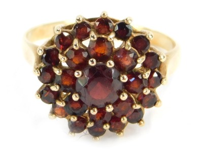 A 9ct gold garnet cluster ring, with three layers of garnets each in a raised basket claw setting, ring size M, 2.9g all in.