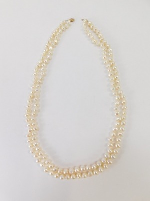 A two row and twist design pearl necklace, with white lustre finish on a string strand with yellow metal clasp, stamped 10kt, 51cm long, 74.6g all in. - 2