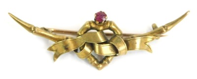 A Victorian bar brooch, wish bone backed with central heart and bowed design, set with garnet, yellow metal, stamped 15ct, 5cm wide, 2.7g all in.