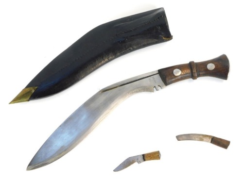 A curved Kukri dagger, marked TD with military arrows and two miniature blades, in a leather scabbard, 45cm wide.