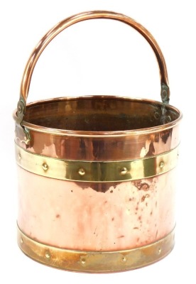 A copper and brass coal bucket, with swing handle and buckle supports, 23cm high, 29cm diameter.