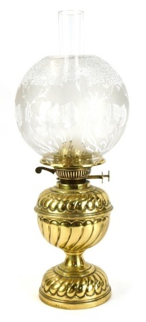 A 19thC brass oil lamp, with domed floral glass shade, on a fluted stem, 40cm high.