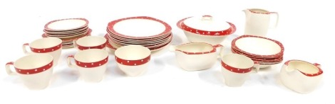 A Midwinter Modern Stylecraft red polka dot tea set, comprising five cups and saucers, two small jugs, teapot lacking lid, tureen and lid, five side plates, seven dinner plates, serving plate and six bowls.