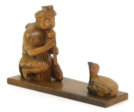 An Eastern hardwood desk stand, with snake charmer with cobra, 14cm high, 21cm wide.