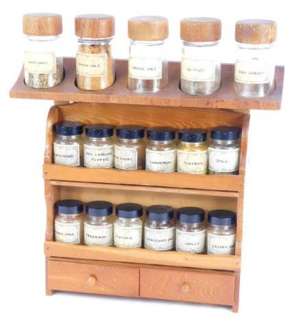 A pine hanging kitchen spice rack, and various glass bottles, 35cm high, 38cm wide.