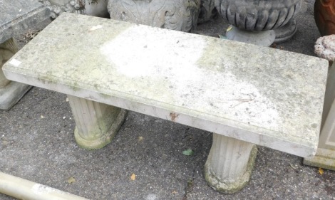 A reconstituted stone garden bench, the rectangular top on two oval plinths, each set with sunflower and Corinthian columns, 42cm high, 95cm wide, 36cm deep.