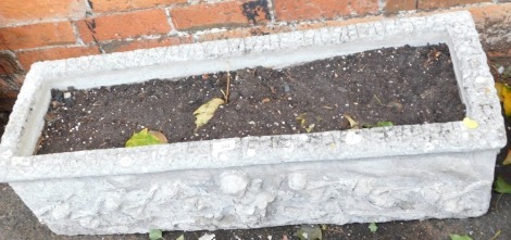 A reconstituted stone rectangular planter, with seven relief moulded cherub figures, 28cm high, 91m wide, 31cm deep.